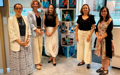 Cinco representantes de Sacyr y Fundación Descúbreme posan junto a una instalación visual en las oficinas de Sacyr en Madrid.